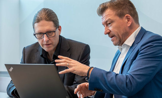 Two experienced consultants working together in a bright modern office.